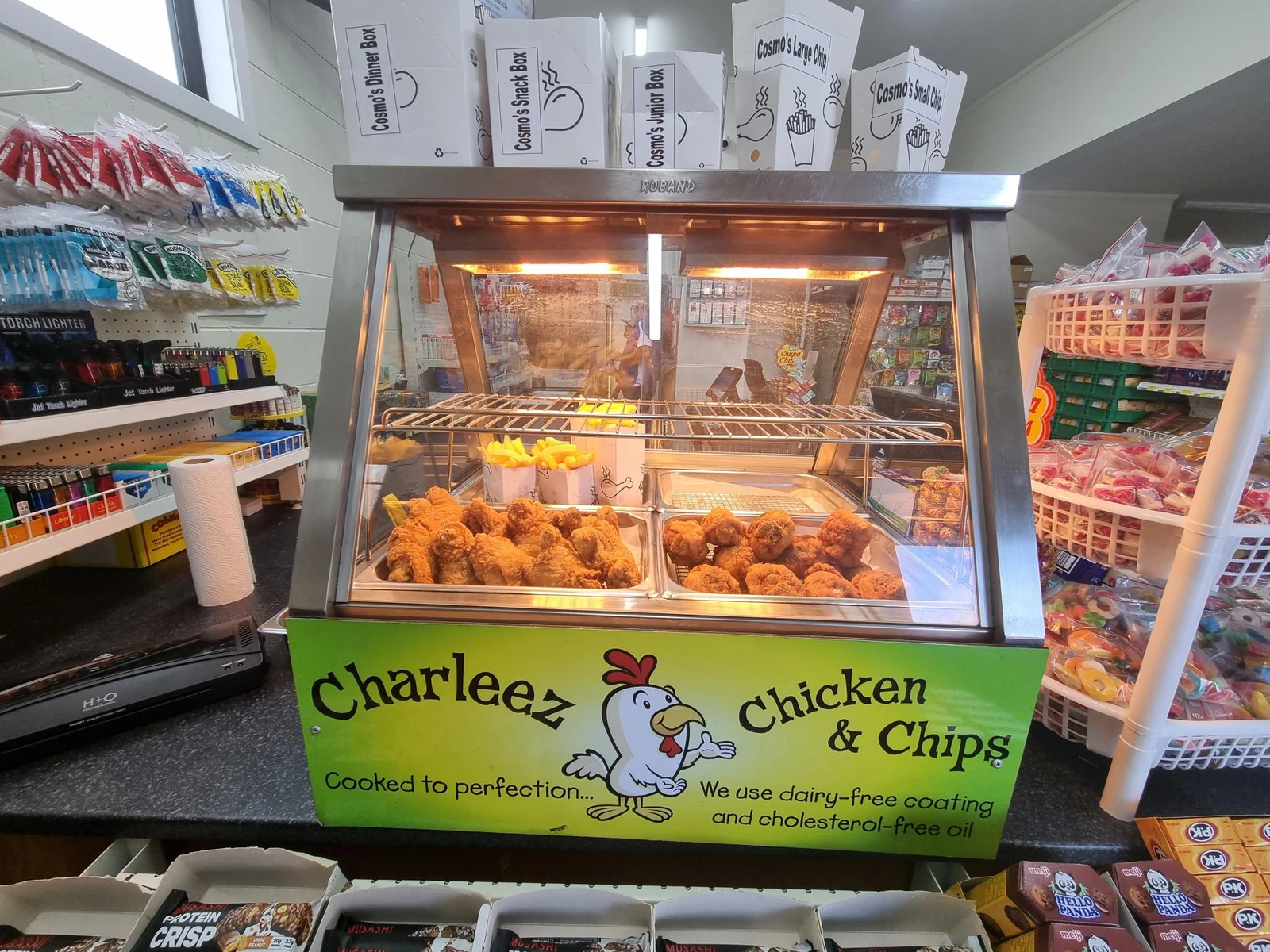 A branded Charleez Chicken & Chips hot food cabinet stocked with fried chicken and chips inside a convenience store