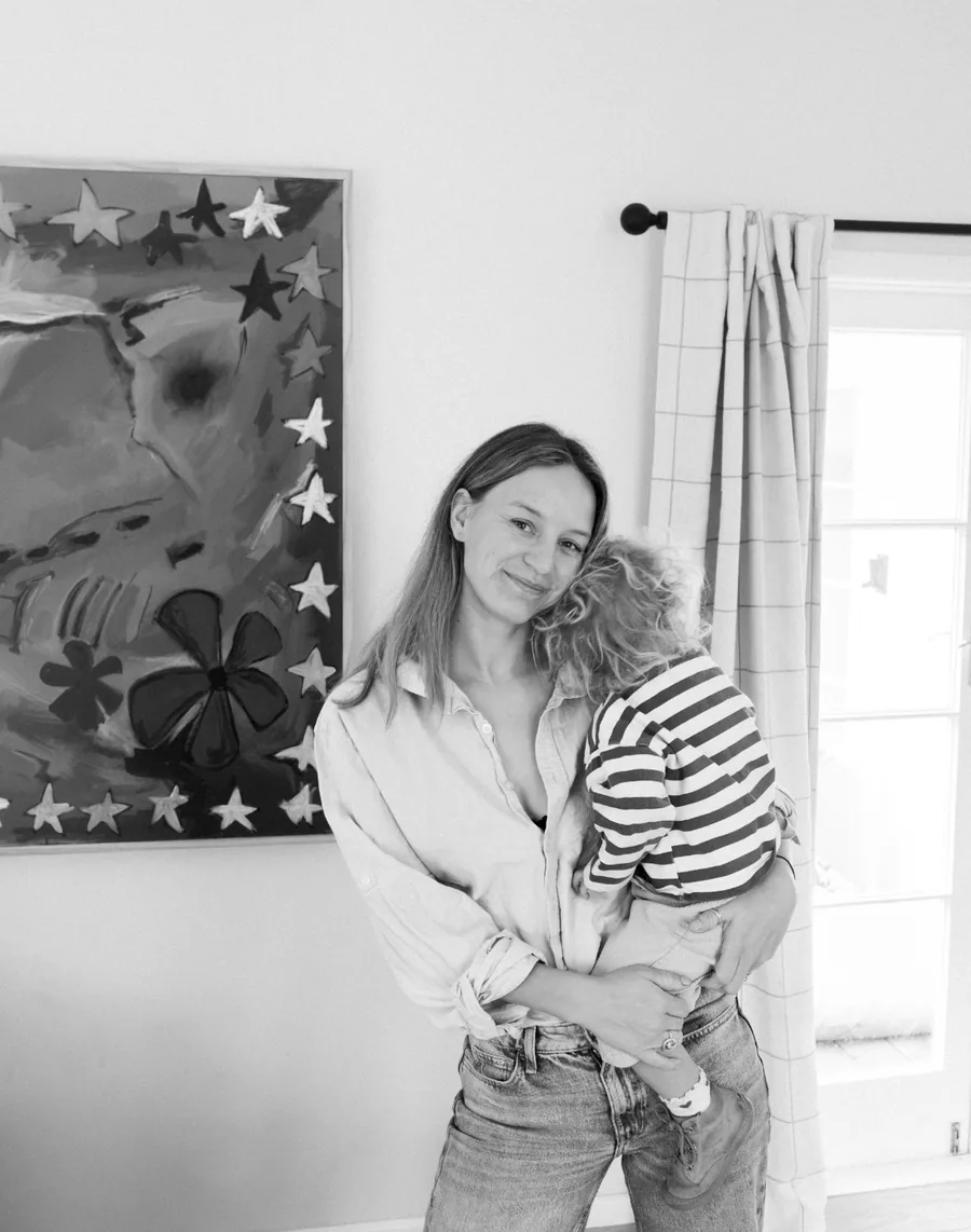 Leslie Crasborn, founder of TinyBum, holding her child at home in Hawke's Bay