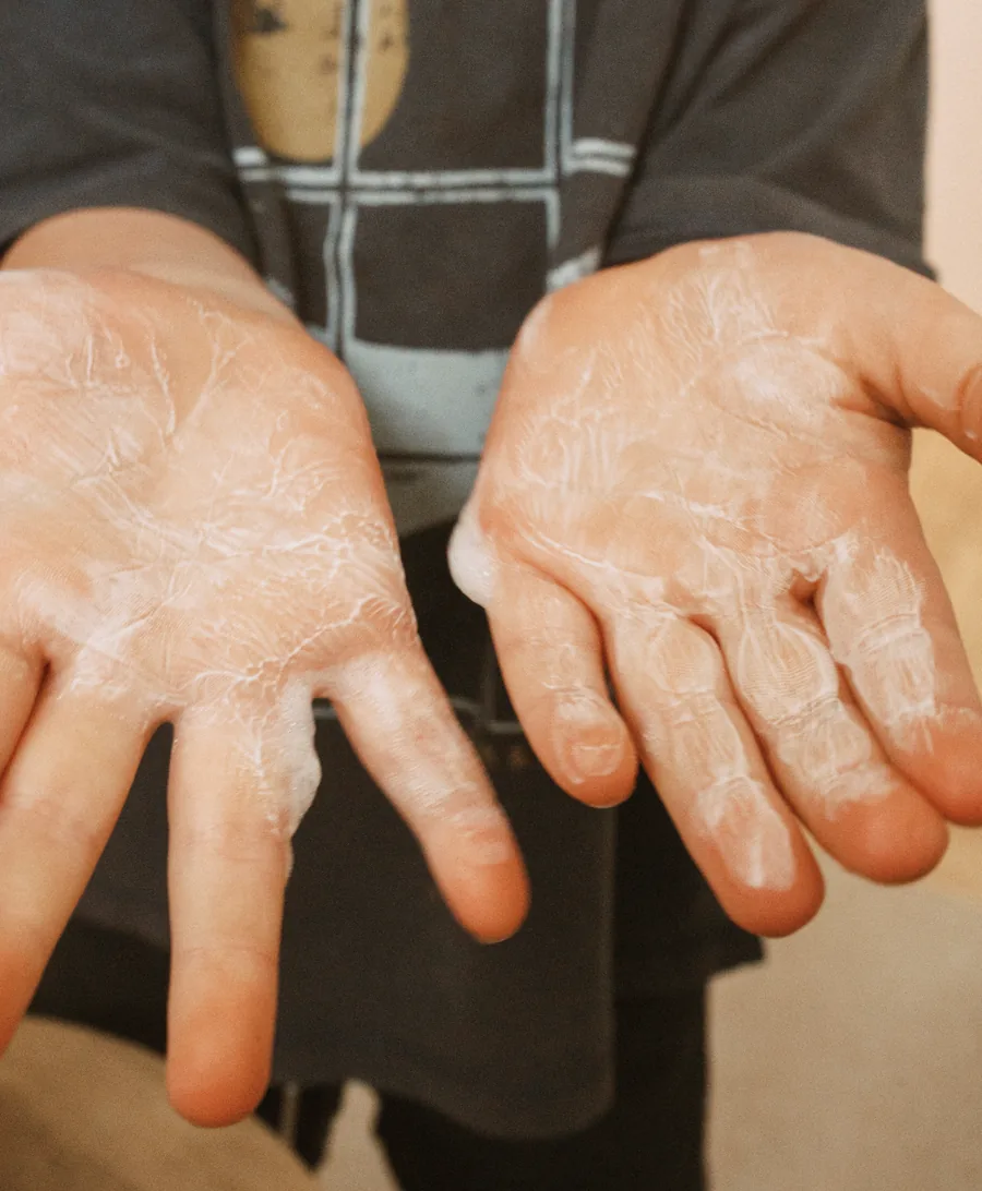 A child's hands covered in TinyBum's gentle no-rinse foam
