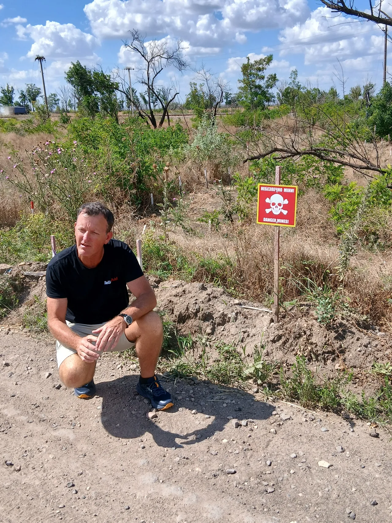 Mike Seawright beside a landmine warning sign in Ukraine